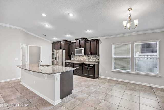 kitchen with a kitchen island with sink, sink, crown molding, appliances with stainless steel finishes, and tasteful backsplash