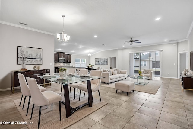 tiled dining room featuring ceiling fan with notable chandelier, ornamental molding, and vaulted ceiling