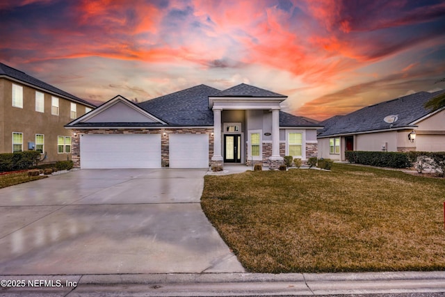 prairie-style home featuring a yard and a garage