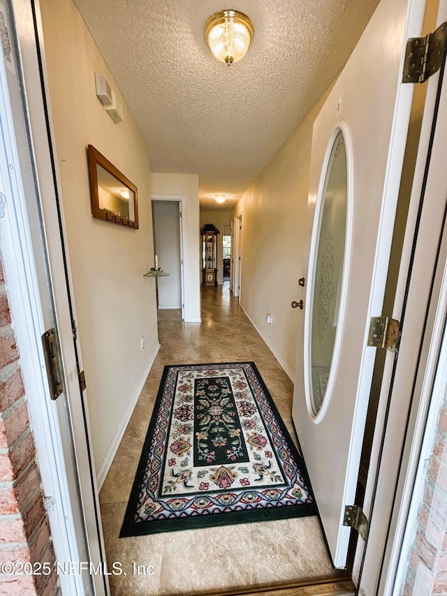 corridor featuring a textured ceiling