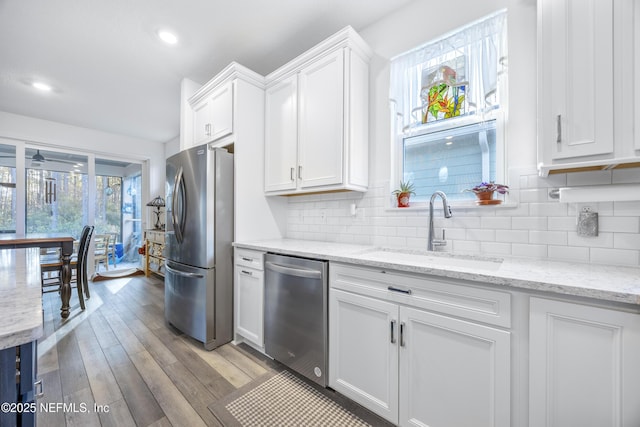 kitchen with white cabinets, sink, appliances with stainless steel finishes, and light hardwood / wood-style flooring