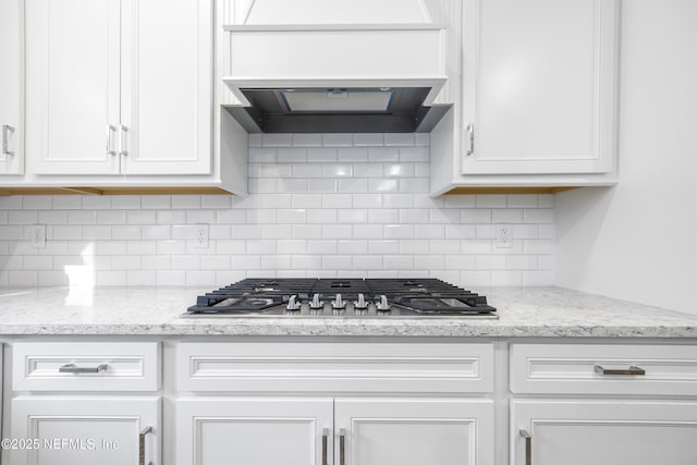 kitchen featuring tasteful backsplash, white cabinetry, and custom range hood