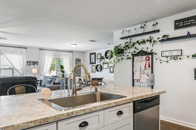 kitchen featuring a textured ceiling, sink, dishwasher, dark hardwood / wood-style floors, and white cabinetry