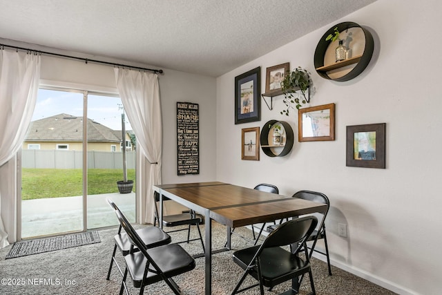 dining space with carpet floors and a textured ceiling