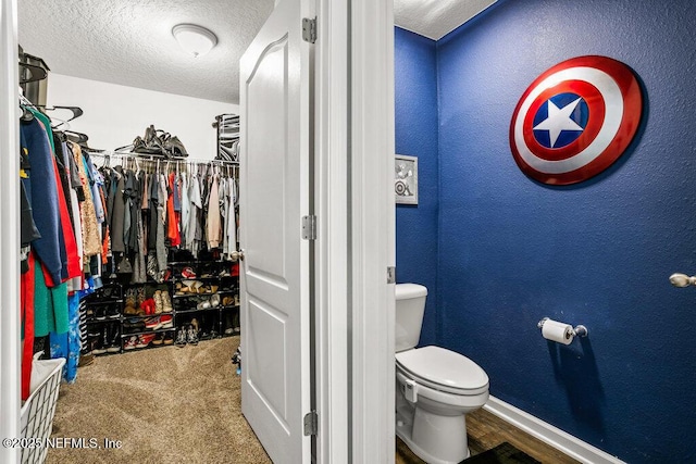 bathroom featuring a textured ceiling and toilet