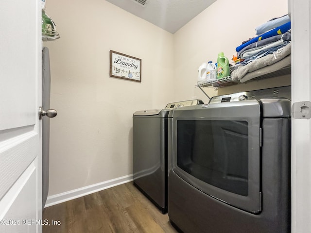 laundry room featuring washing machine and clothes dryer and dark hardwood / wood-style flooring