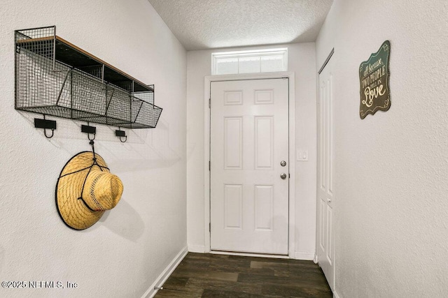 doorway with a textured ceiling and dark hardwood / wood-style floors