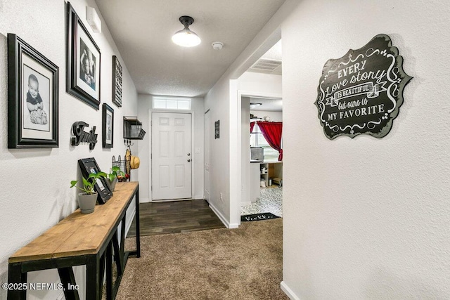 interior space featuring dark carpet and a textured ceiling