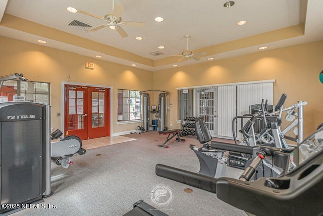 workout area with french doors, a raised ceiling, and ceiling fan