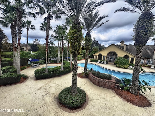 view of swimming pool featuring a jacuzzi and a patio area