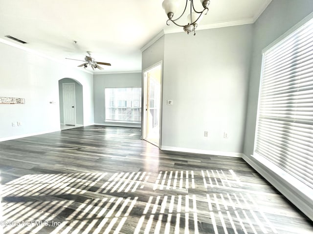 empty room featuring crown molding, dark hardwood / wood-style floors, and ceiling fan with notable chandelier