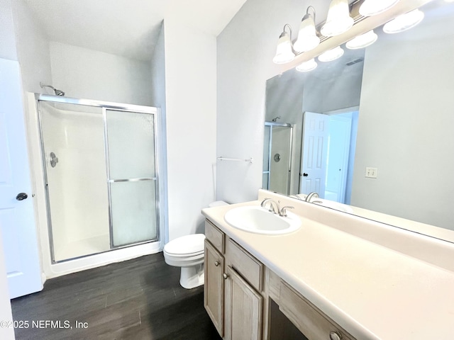 bathroom with vanity, toilet, an enclosed shower, and hardwood / wood-style floors