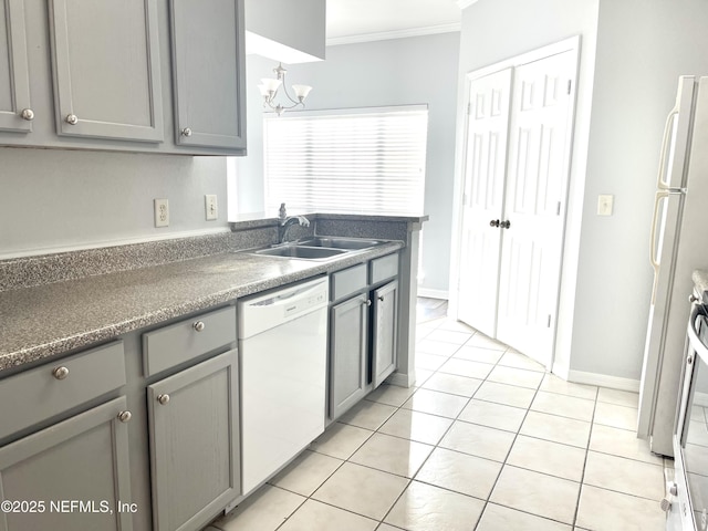 kitchen with gray cabinets, sink, light tile patterned floors, crown molding, and white appliances