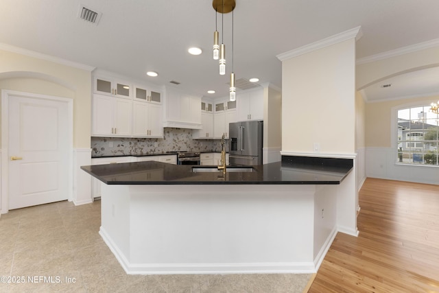 kitchen featuring pendant lighting, white cabinets, sink, ornamental molding, and appliances with stainless steel finishes