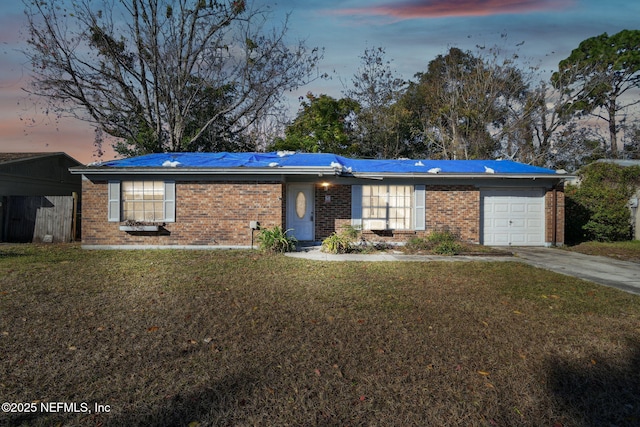 ranch-style house featuring a garage and a yard