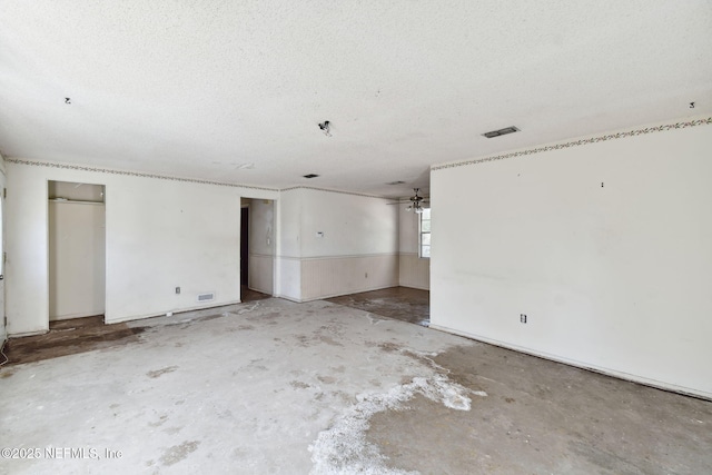 spare room with ceiling fan, concrete floors, and a textured ceiling