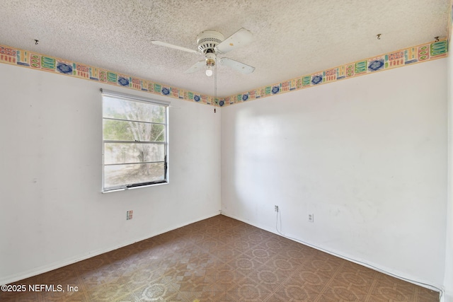 unfurnished room with ceiling fan and a textured ceiling