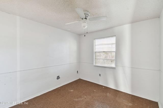 empty room featuring ceiling fan and a textured ceiling