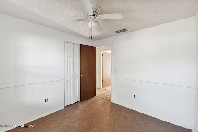 unfurnished bedroom featuring ceiling fan, a textured ceiling, and a closet