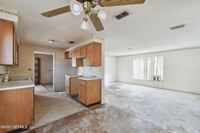 kitchen featuring a textured ceiling, ceiling fan, and sink