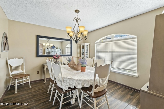 dining space featuring a textured ceiling, an inviting chandelier, a wealth of natural light, and dark hardwood / wood-style flooring