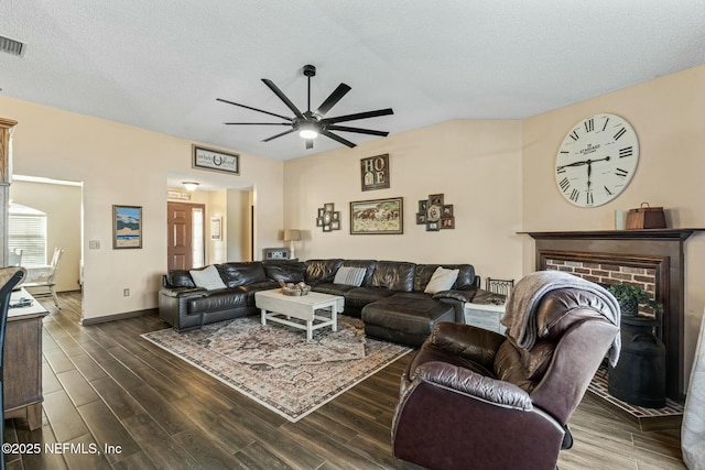 living room with ceiling fan, a fireplace, and a textured ceiling