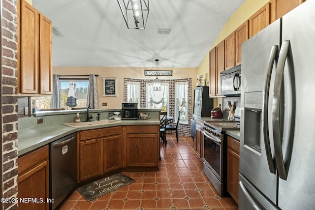 kitchen with pendant lighting, appliances with stainless steel finishes, a textured ceiling, lofted ceiling, and sink