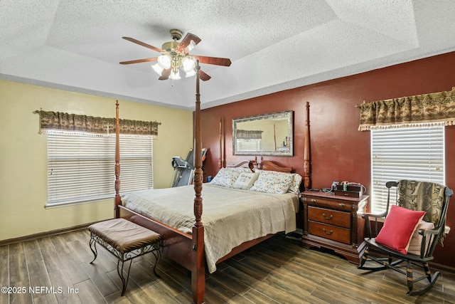 bedroom with ceiling fan and a tray ceiling