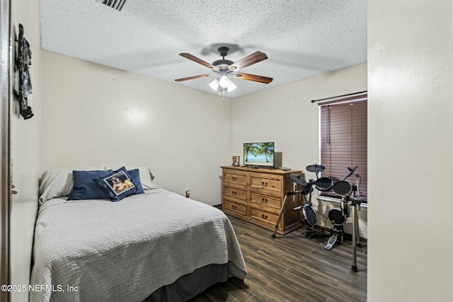 bedroom with ceiling fan, dark hardwood / wood-style flooring, and a textured ceiling