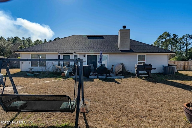 exterior space featuring a front yard, central air condition unit, and a patio