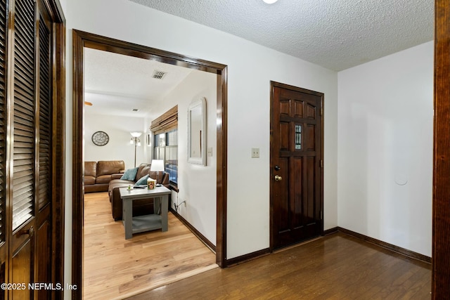 hall featuring a textured ceiling and hardwood / wood-style flooring