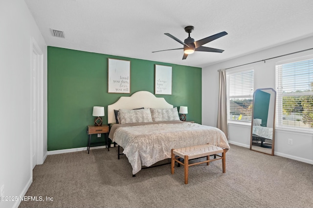 carpeted bedroom featuring ceiling fan and a textured ceiling