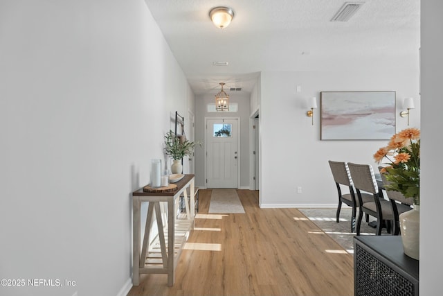 foyer featuring a textured ceiling and light wood-type flooring