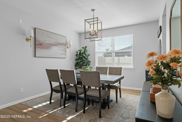 dining room with a textured ceiling, an inviting chandelier, and dark wood-type flooring