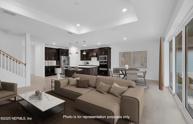 living room with crown molding, a raised ceiling, and sink