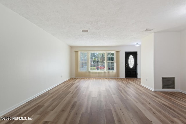 foyer with hardwood / wood-style flooring and a textured ceiling