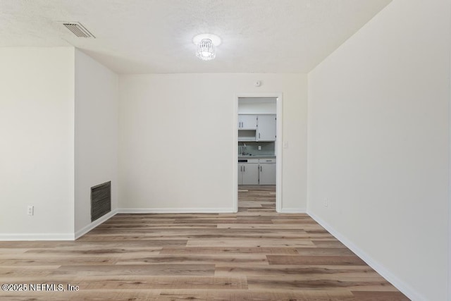 unfurnished room with light hardwood / wood-style flooring and sink