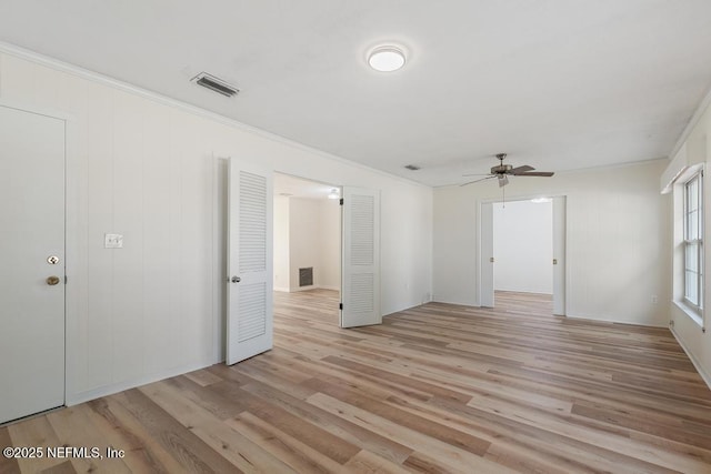 empty room with ceiling fan, light hardwood / wood-style floors, and ornamental molding