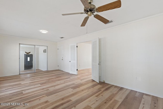 empty room with ceiling fan, crown molding, and light hardwood / wood-style flooring