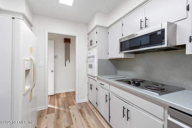 kitchen with backsplash, white cabinetry, light hardwood / wood-style flooring, and white appliances