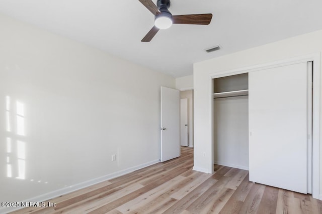 unfurnished bedroom with light wood-type flooring, a closet, and ceiling fan