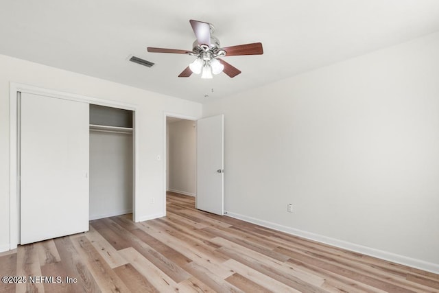 unfurnished bedroom featuring ceiling fan, light hardwood / wood-style floors, and a closet