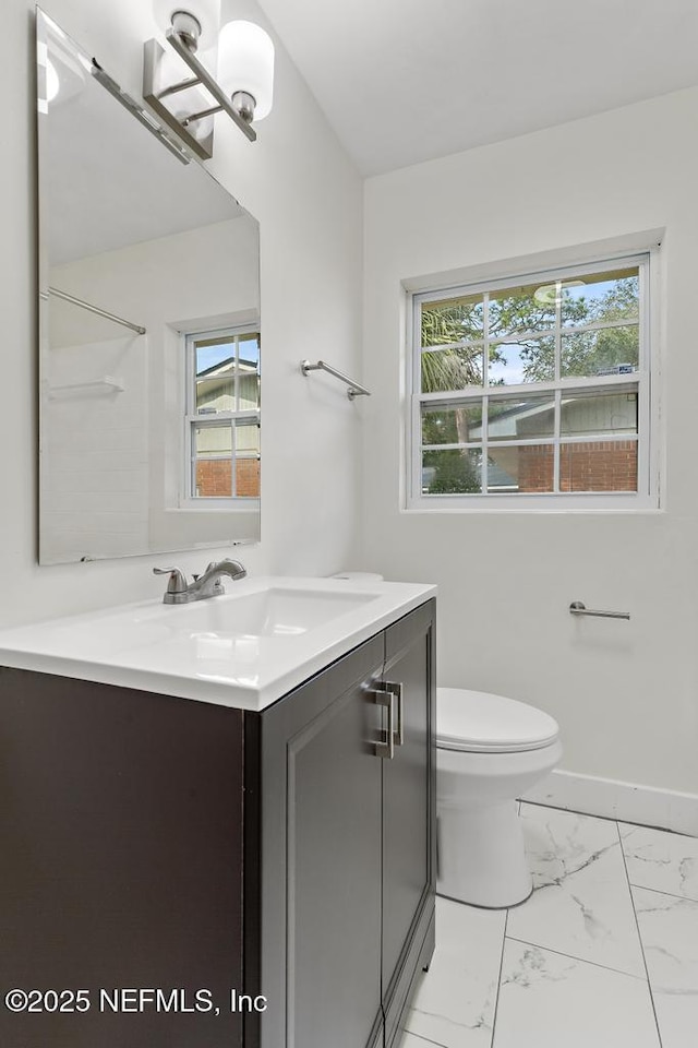 bathroom with vanity, toilet, and plenty of natural light