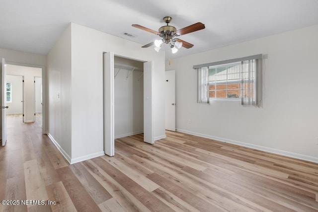 unfurnished bedroom with ceiling fan, light wood-type flooring, and a closet