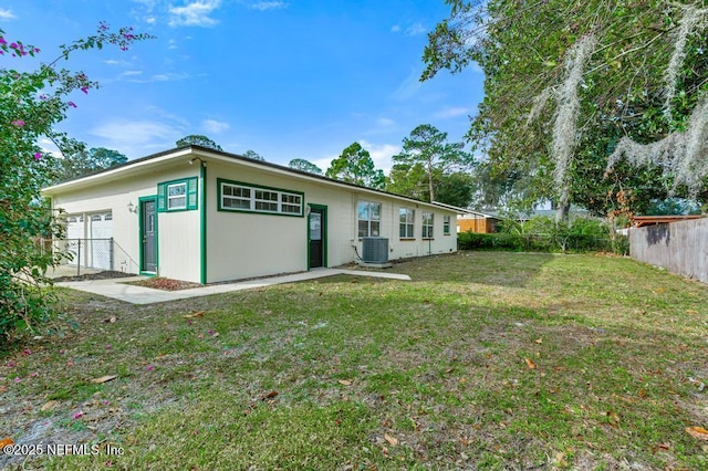 back of house featuring central AC and a yard