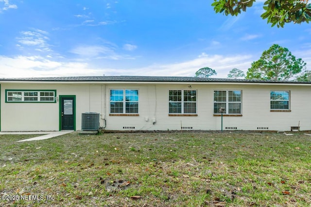 rear view of property with cooling unit and a lawn