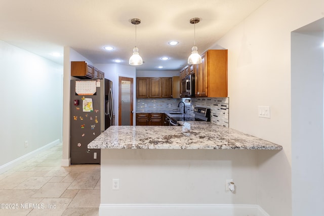 kitchen with tasteful backsplash, light stone counters, kitchen peninsula, pendant lighting, and appliances with stainless steel finishes