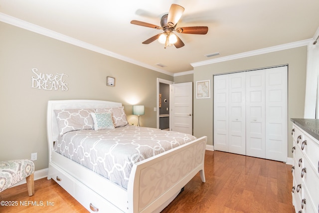 bedroom with light wood-type flooring, a closet, ceiling fan, and ornamental molding