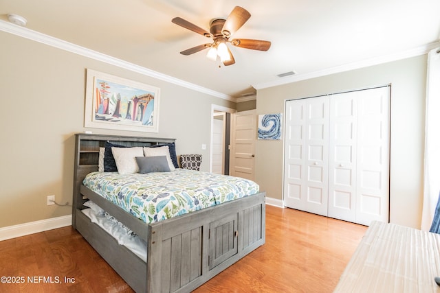 bedroom with hardwood / wood-style flooring, ceiling fan, a closet, and ornamental molding