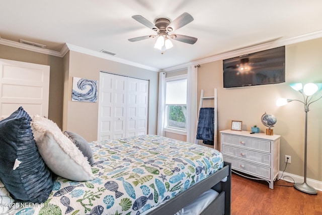 bedroom with ceiling fan, ornamental molding, dark wood-type flooring, and a closet